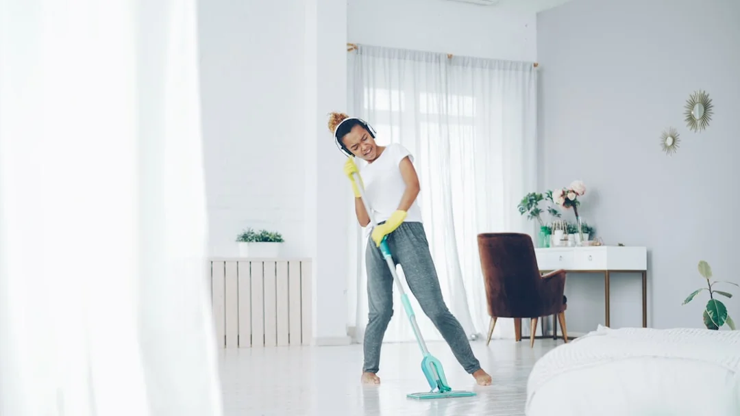 about-us-01 A person in protective gear disinfecting a carpet with a fumigation device indoors.